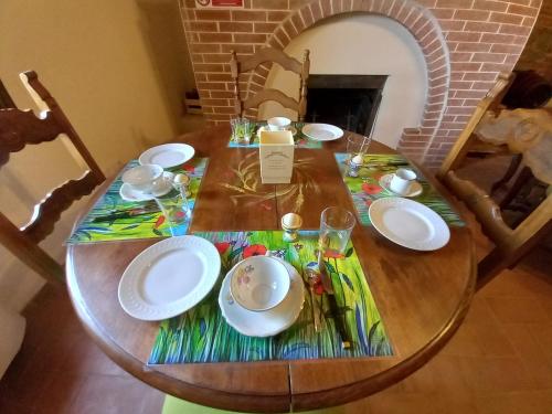 a wooden table with plates and dishes on it at Agriturismo Podere Padolecchie - Azienda Agricola Passerini in Torrita di Siena