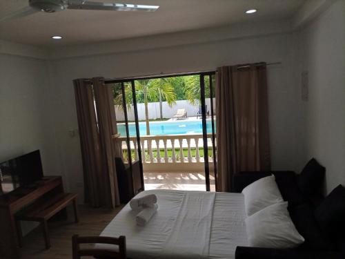 - une chambre avec un lit et une porte coulissante en verre dans l'établissement Portofino Panglao Bohol, à Panglao