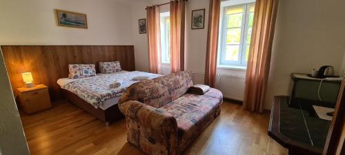 a bedroom with a couch and a bed and a couch and a chair at Pension Pod Lipou in Loučovice