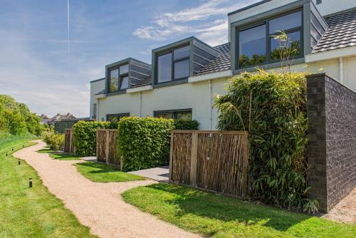 ein Haus mit einem Zaun und einem Weg in der Unterkunft Villa Zoutelande in Zoutelande