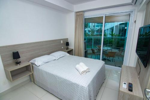 a hotel room with a bed and a balcony at In Mare Bali #37 - Triplo em Cotovelo by Carpediem in Parnamirim