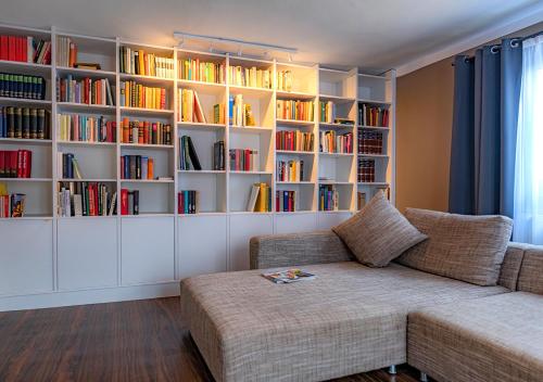 a living room with a couch and bookshelves at Boutique-Hotel Zum Grünen Baum in Alzenau in Unterfranken