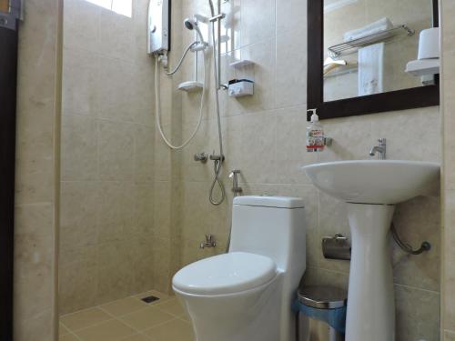 La salle de bains est pourvue d'une douche, de toilettes et d'un lavabo. dans l'établissement Beach Palace, à Hulhumalé