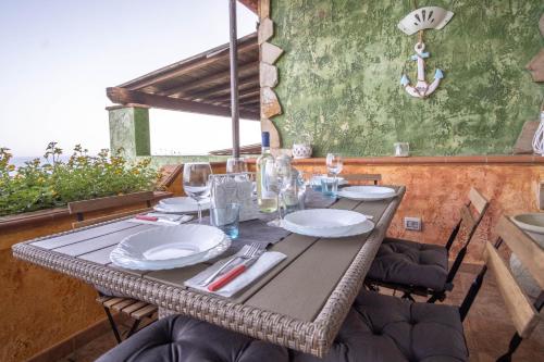 a table with plates and wine glasses on a patio at Porto Corallo Frontemare in Villaputzu