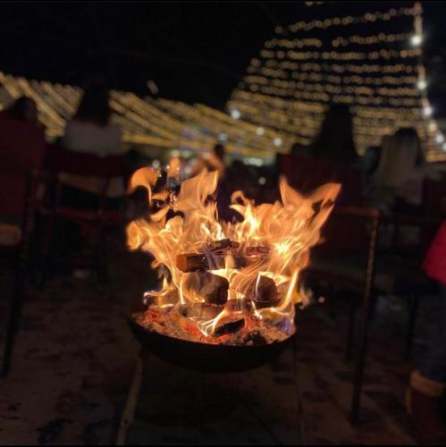 a fire pit with flames in it at night at Pazari Vjeter Rooms in Korçë