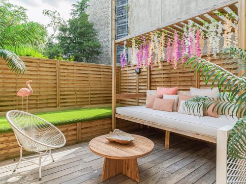une terrasse avec un canapé, une table et un flamingo dans l'établissement Rose & Garden - Eiffel Tower, à Paris