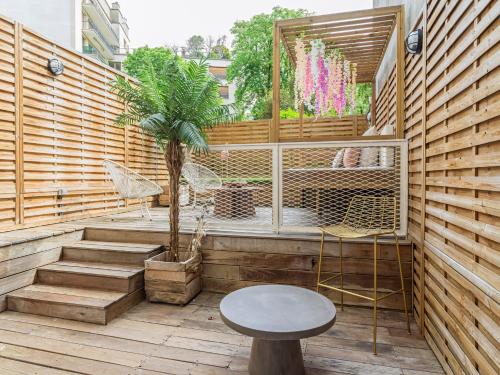 d'une terrasse avec une table, des chaises et un arbre. dans l'établissement Rose & Garden - Eiffel Tower, à Paris