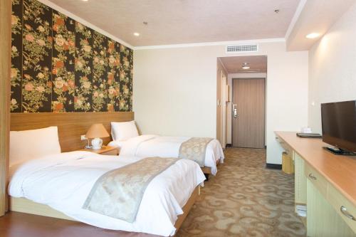 a hotel room with two beds and a television at APVC Lukang Resort in Lugang