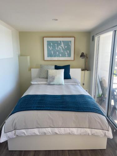 a bedroom with a large bed with blue and white sheets at Just Relax & in Boat Harbour
