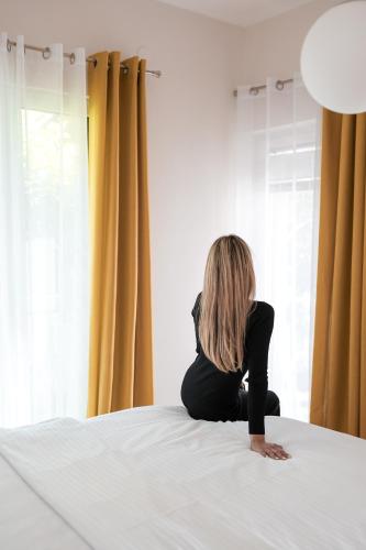 a woman sitting on top of a bed at Villa Dea in Kotor