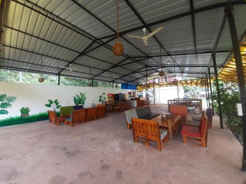 a large patio with tables and chairs in a building at Radhika Eco Resort(Odonata) in Arambol