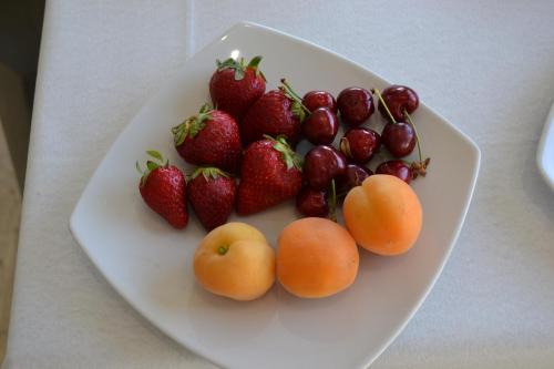 a plate of strawberries and cherries and oranges on a table at B&B Sole&Sale in San Leone