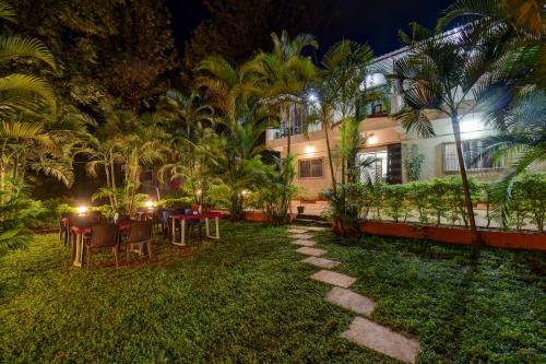 a garden with tables and chairs in front of a building at Hotel Silver Inn in Mahabaleshwar