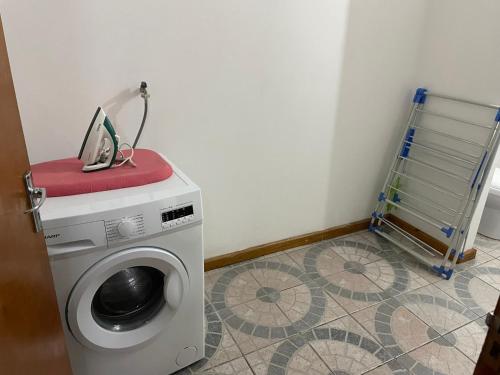 a washing machine in a room with a tiled floor at MARL Self Catering in Pointe Larue