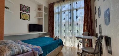 a bedroom with a bed and a window with a table at Dzveli Batumi in Batumi