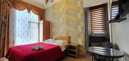 a bedroom with a bed with a red blanket at Dzveli Batumi in Batumi