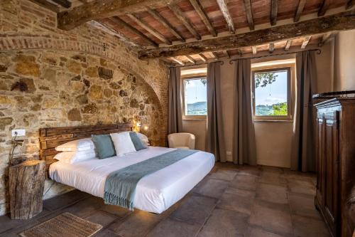 a bedroom with a bed in a stone wall at Stelle di Monte in Montepulciano