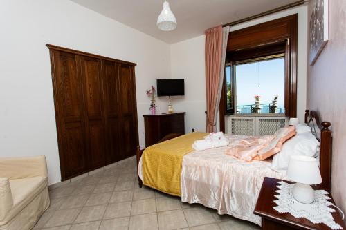 a bedroom with a bed with a yellow blanket and a window at Apartments PARADISE GARDEN Holiday House in Agerola