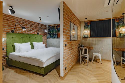 a bedroom with a bed, a chair, and a fireplace at ONE66 Hotel in Ljubljana