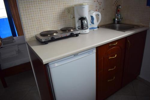 a kitchen counter with a stove and a sink at Zorbas Studios in Agia Roumeli