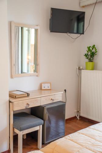a desk in a bedroom with a mirror and a television at Marabou Hotel Chorefto in Chorefto
