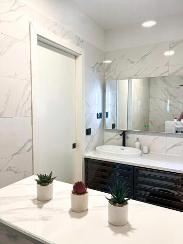 ein weißes Badezimmer mit einer Badewanne und einem Waschbecken in der Unterkunft SanOne-Studio apartment in Jesenice