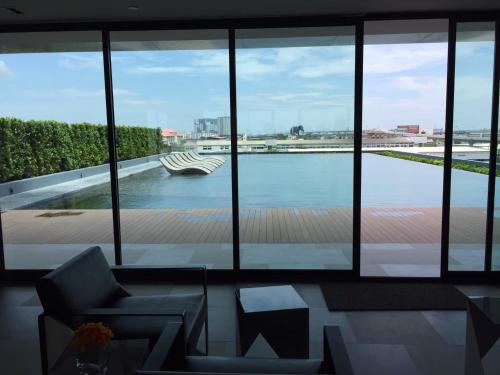 een woonkamer met uitzicht op het water bij Ideo S115 New luxury condominium at Sukhumvit 115 in Ban Khlong Samrong