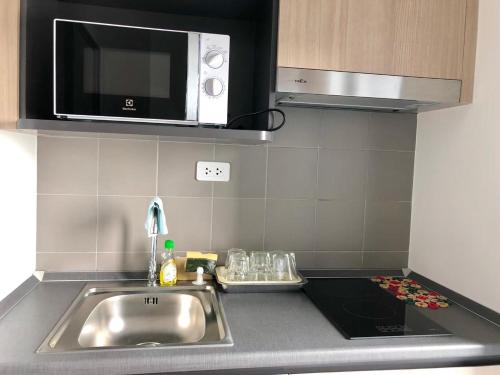 a kitchen counter with a sink and a microwave at Ideo S115 New luxury condominium at Sukhumvit 115 in Ban Khlong Samrong