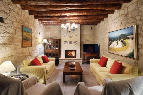 a living room with two couches and a fireplace at KANTARA HOUSE - A Rural Retreat of Comfort & Class! in Arsos