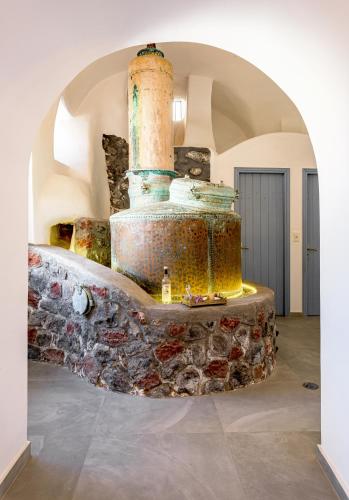 a stone stove in a room with an archway at Anatoli Hotel & Spa in Fira