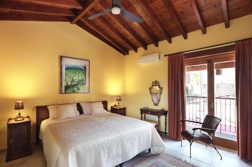 a bedroom with a bed and a chair and a window at KANTARA HOUSE - A Rural Retreat of Comfort & Class! in Arsos