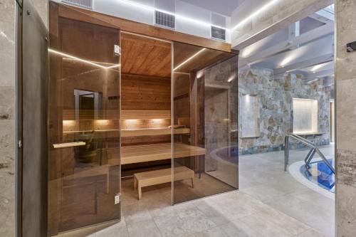 a sauna in a bathroom with a glass wall at Spa Hotel Villa Ritter in Karlovy Vary