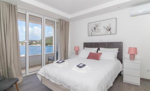 een slaapkamer met een bed en een groot raam bij Seaside Apartment M Zaton 3 -SeaView and Parking in Zaton