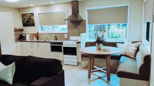 a kitchen and living room with a table and a couch at Adventure Bay Holiday Home in Adventure Bay