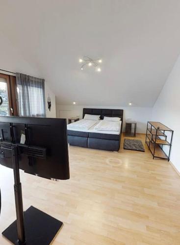 a large living room with a bed and a wooden floor at FERIENHAUS in der Natur in Wüstenrot