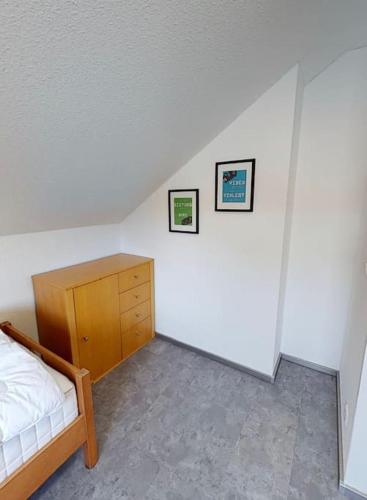 a bedroom with a bed and a wooden dresser at FERIENHAUS in der Natur in Wüstenrot