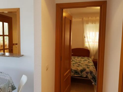 a bedroom with a door leading to a bed at Magic World Frontal 1ª línea in Oropesa del Mar