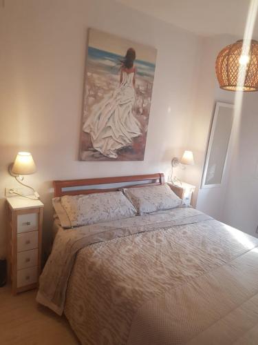 a bedroom with a bed with a painting on the wall at Magic World Frontal 1ª línea in Oropesa del Mar