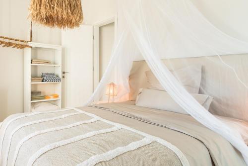 a bedroom with a white bed with a mosquito net at Shangri-La in Meganisi