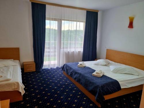 a hotel room with two beds and a window at Pensiunea Riffelt in Bran