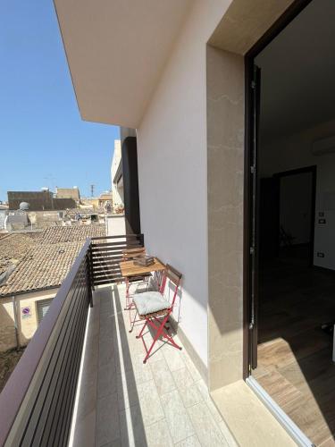 a balcony with a table and chairs on a roof at Domus Solis in Pachino