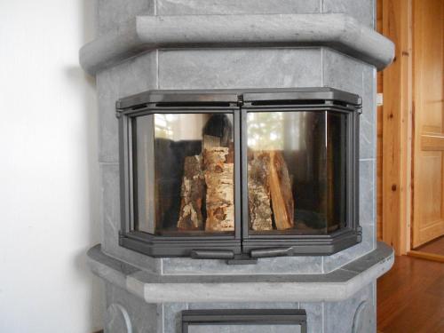 a stone fireplace with logs inside of it at Tornvillan in Hammarland