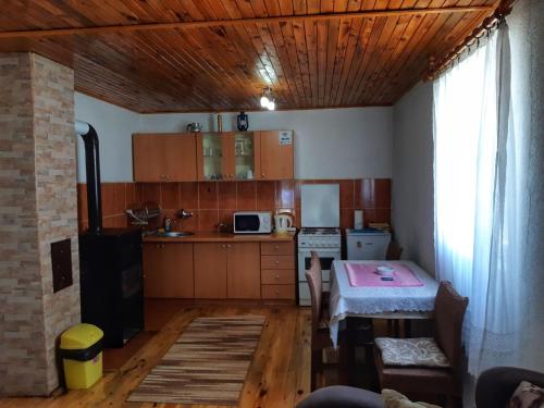 a kitchen with wooden cabinets and a table in a room at Apartments Sipcic in Žabljak