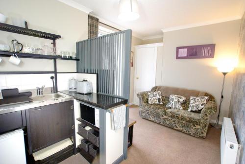 uma sala de estar com um lavatório e um sofá em Craignair Cottage em Dalbeattie