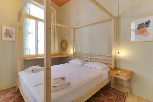 a bedroom with a four poster bed and a window at athensvintage in Athens