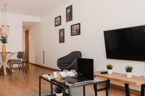 a living room with a laptop on a table and a television at Patacona Beach Apartment in Alboraya