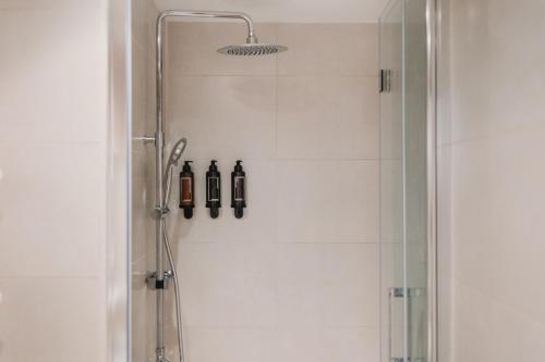 a shower with a glass door with two bottles at Patacona Beach Apartment in Alboraya