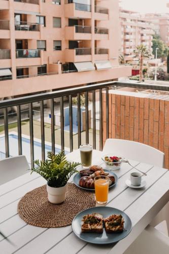 a table with two plates of food on a balcony at Patacona Beach Apartment in Alboraya