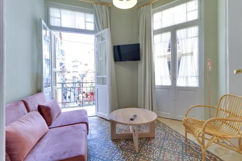 un salon avec un canapé violet et une table dans l'établissement athensvintage, à Athènes