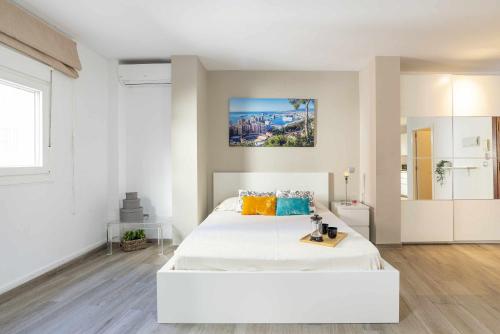 a white bedroom with a large white bed in it at Loft Santa Lucia Centro in Málaga